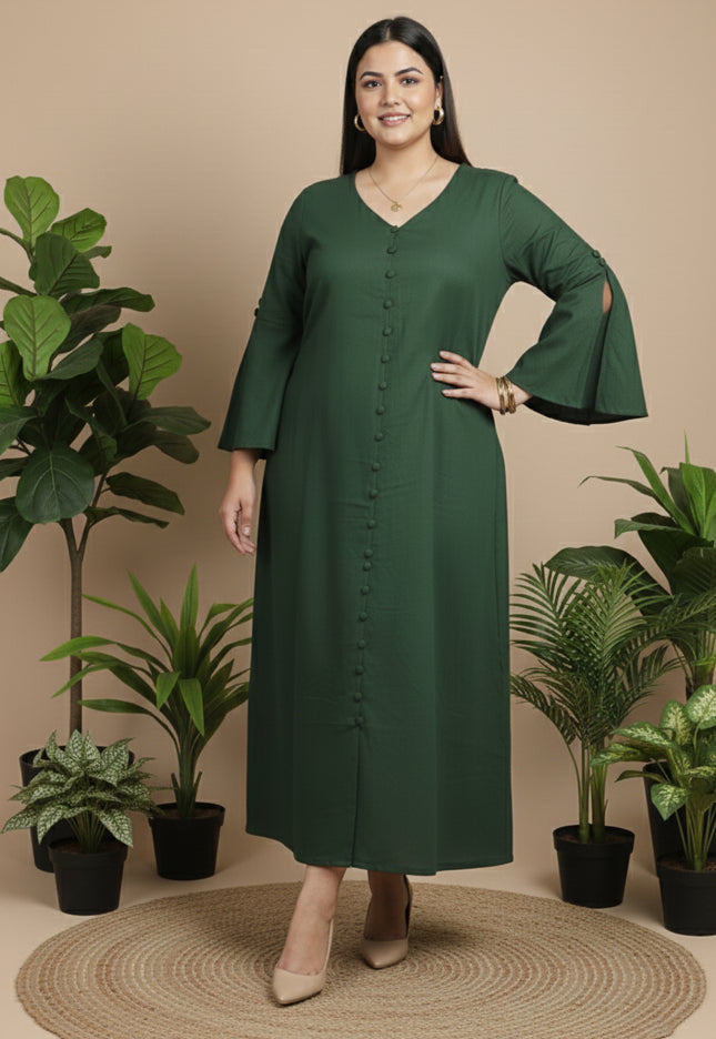 Woman wearing a green dress standing in front of potted plants on a beige background