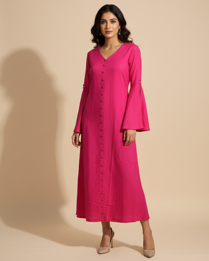 Woman wearing a pink dress with bell sleeves against a beige background